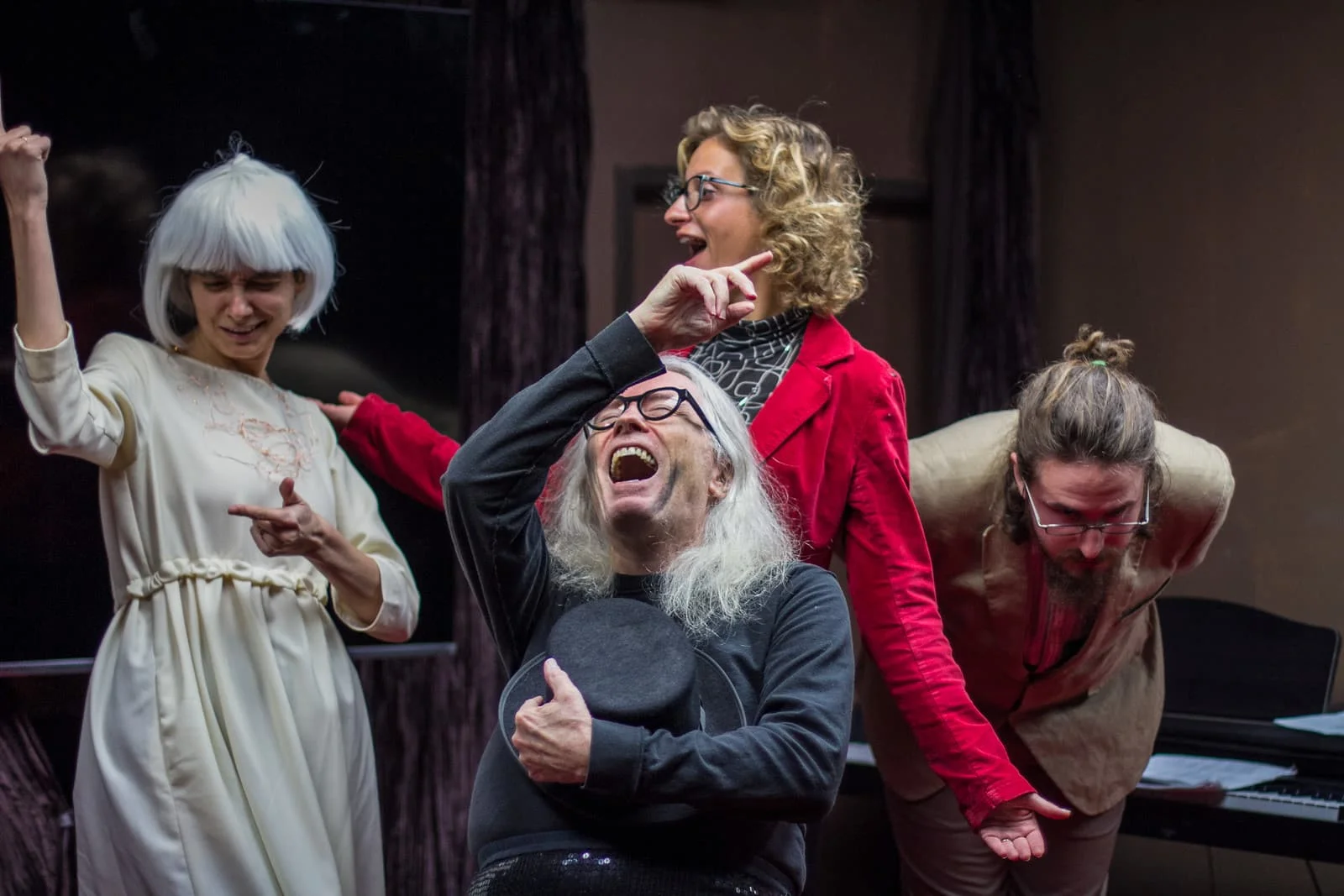 four people performing in a theater with excited expressions