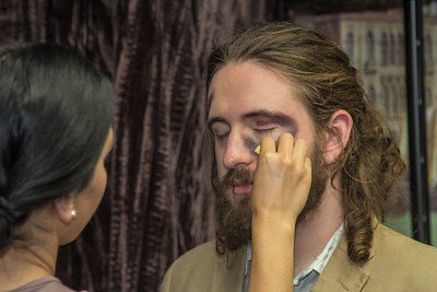 an actor is having make up applied to look like bruises