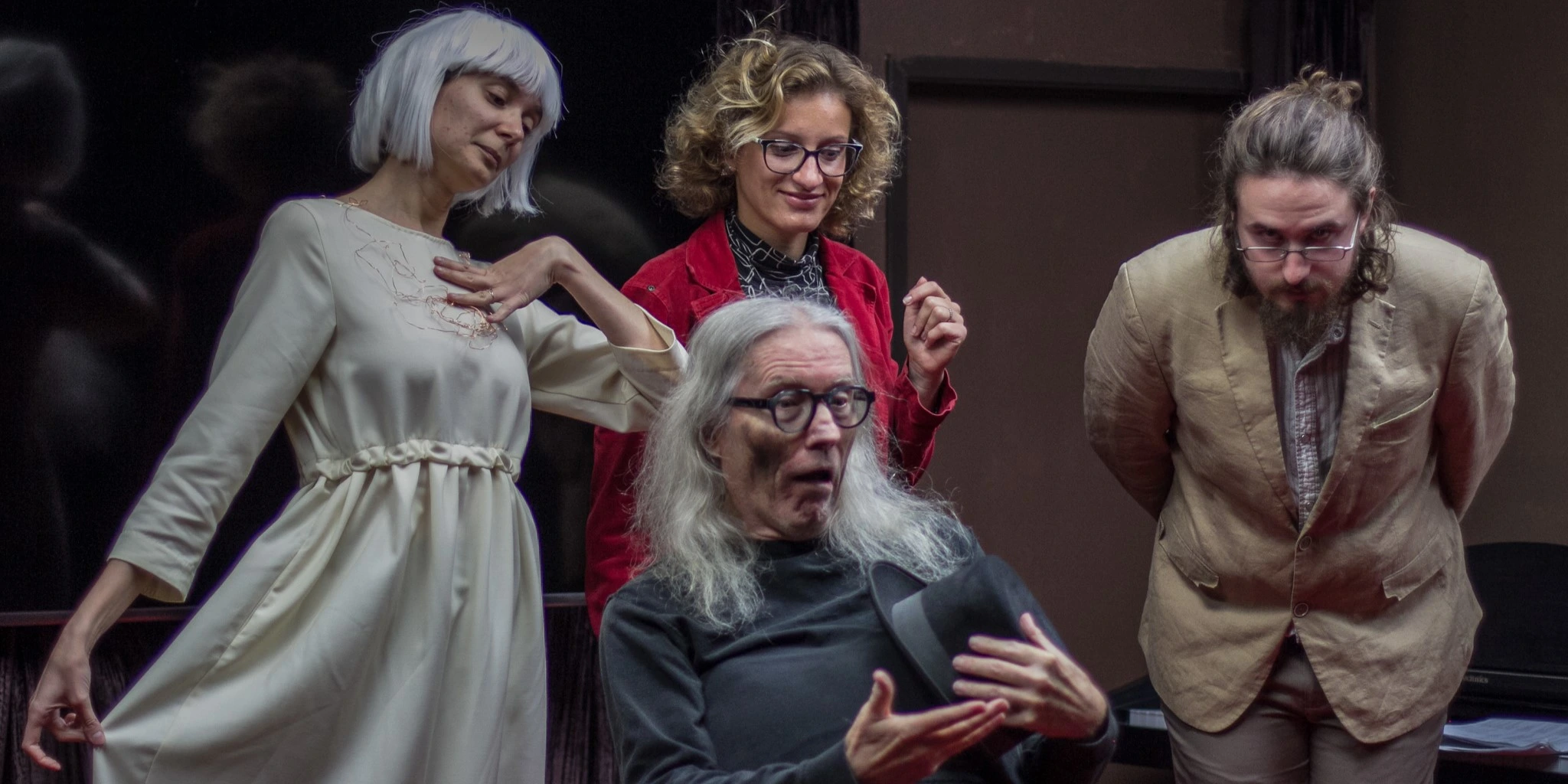 Four actors performing in costume for the play "Kraft."